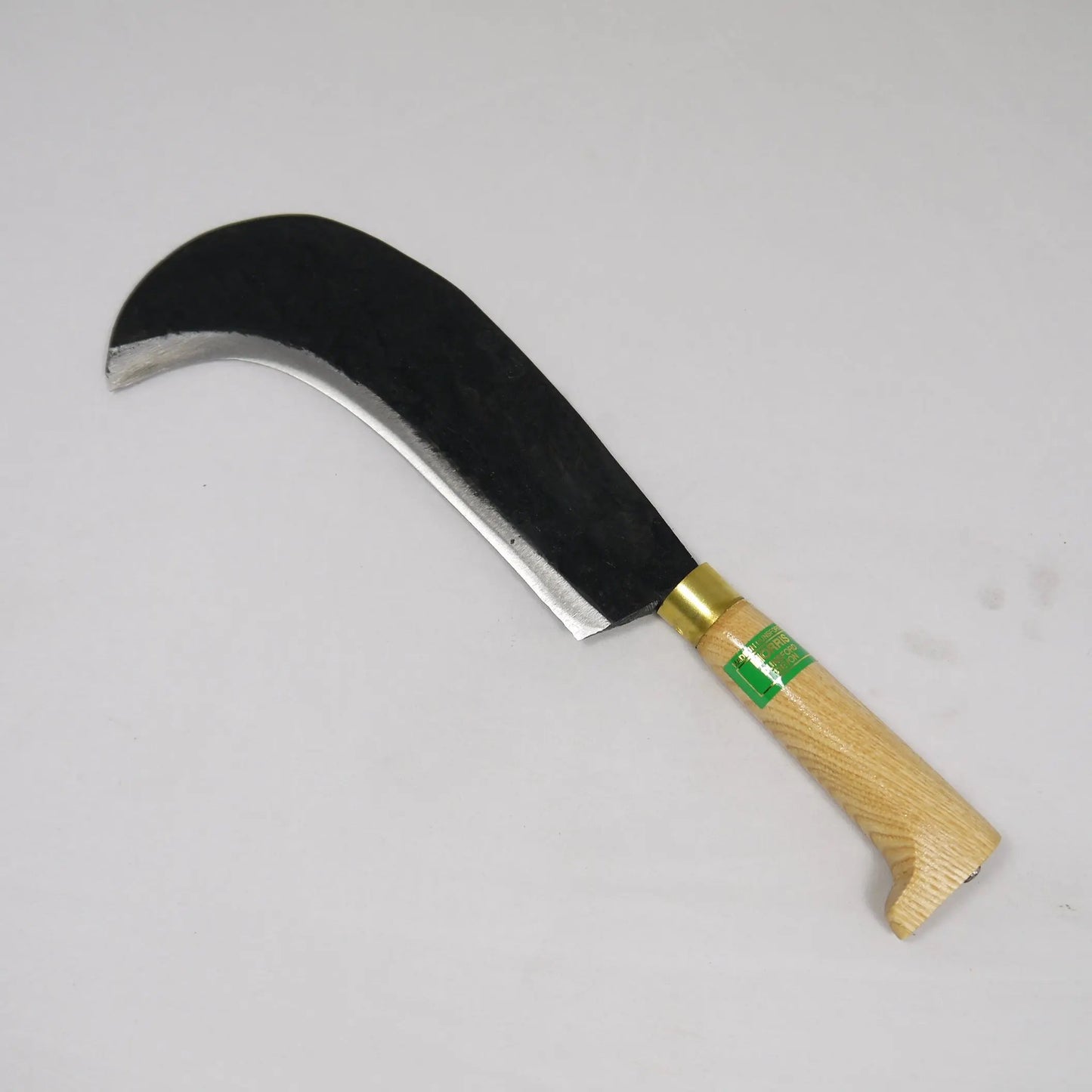 Sickle with wooden handle and metal blade on a gray background