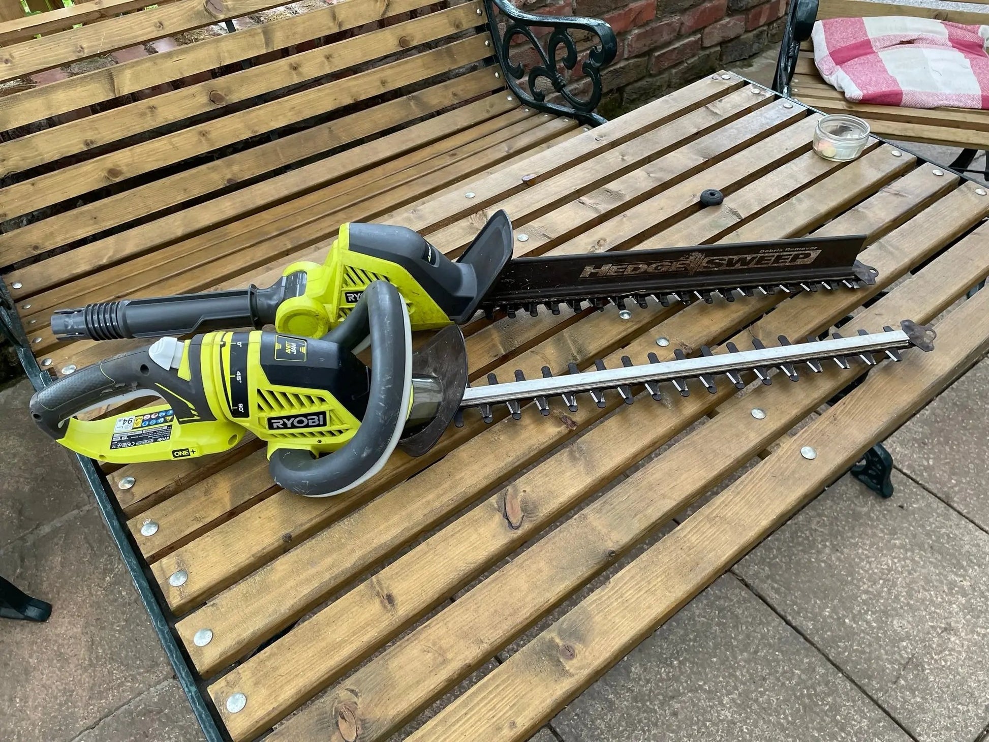 Hedge trimmer on a wooden bench outdoors