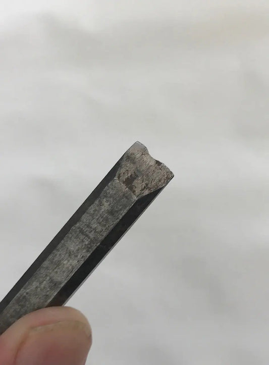 Close-up of a worn-out chisel on a white background